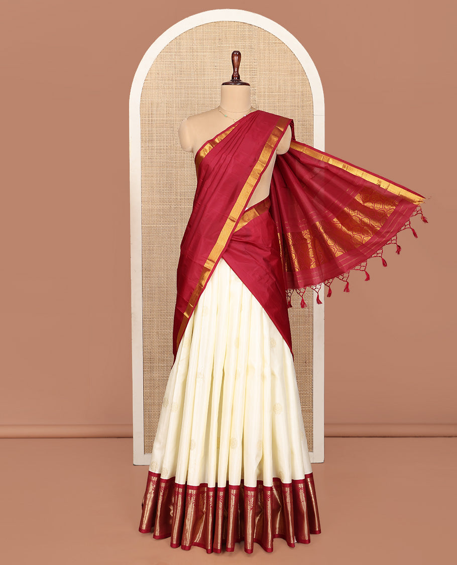 Cream Pure Silk Half-Saree, Enthralled with Zari Buttas All Over Its Skirt, Complemented by Contrast Wedding-Theme Border of Poo Chakram and Rudraksham Designs, Paired with a Contrast Blouse, and Comes with a Dhavani of Ogee Patterns