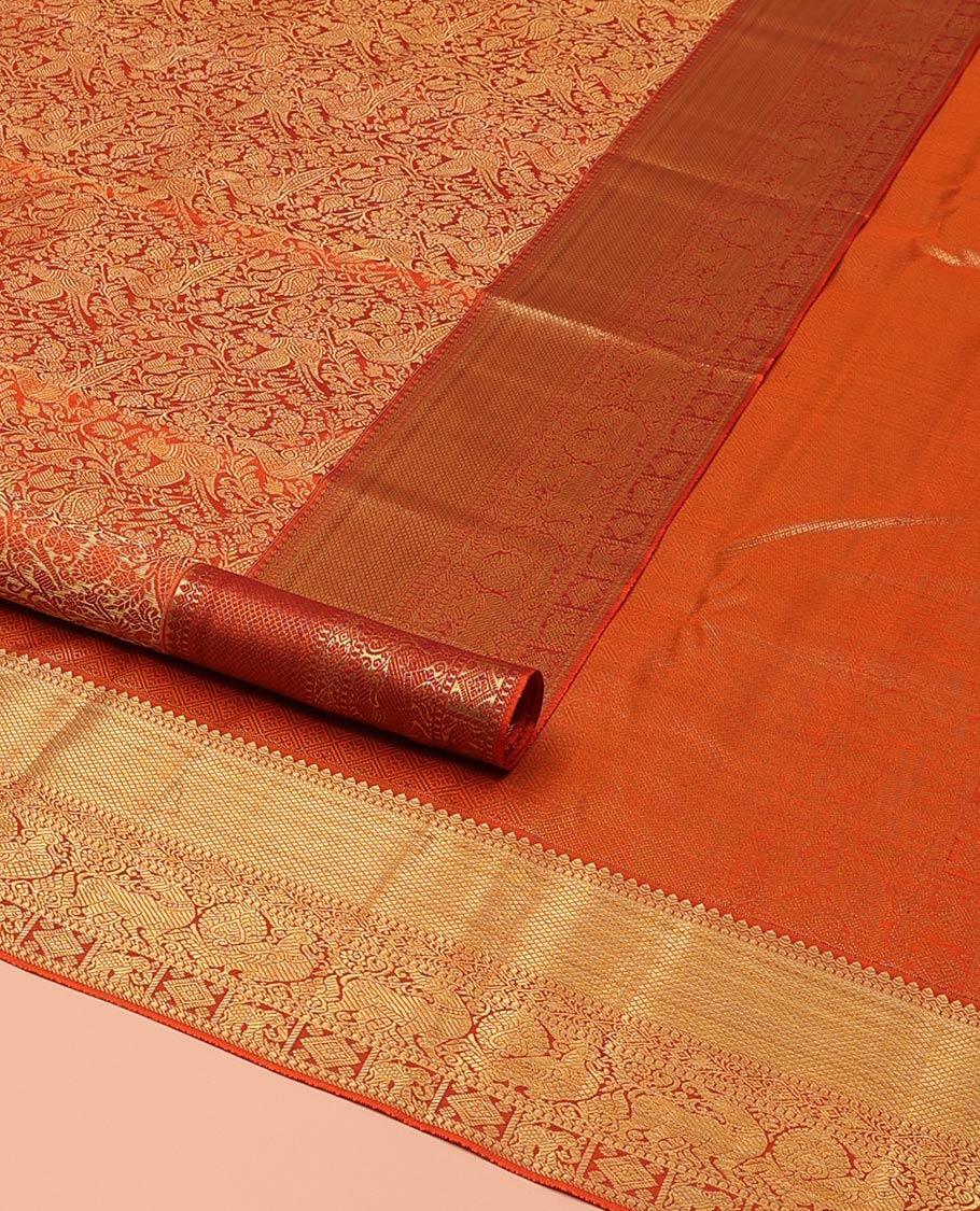 Orange Kanchipuram Wedding Silk Saree, Artfully Detailed with Jacquard Design on Its Body, Highlighted by Zari Border of Thilakam, Kuyil Kann, Diamond, Mayil, Yaali, and Yaanai Designs, Grand Jaal Pallu, and Paired with a Matching Blouse