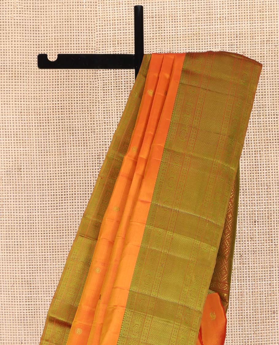 Orange Kanchipuram Silk Saree, Subtly Sparkled with Mayil-Chakram Buttas All Over Its Body, Complemented by a Contrast Border of Rekku, Kamalam, Poun, Chakram, Kuyil Kann, and Then Kuli Kann Designs, Jaal Design Pallu, and Paired with a Contrast Blouse