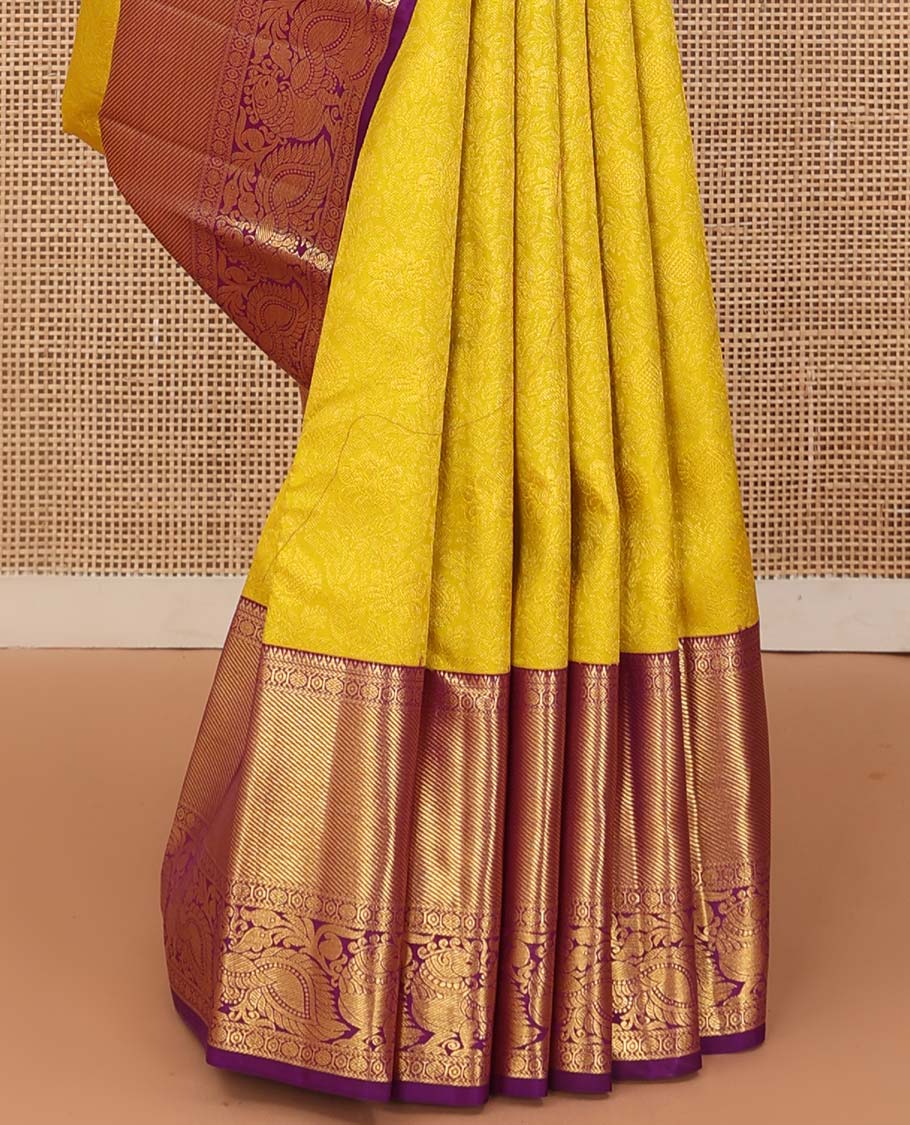 Yellow jacquard wedding silk saree, contrast border of thilakam, rudraksham, and mayil designs, and ogee design pallu