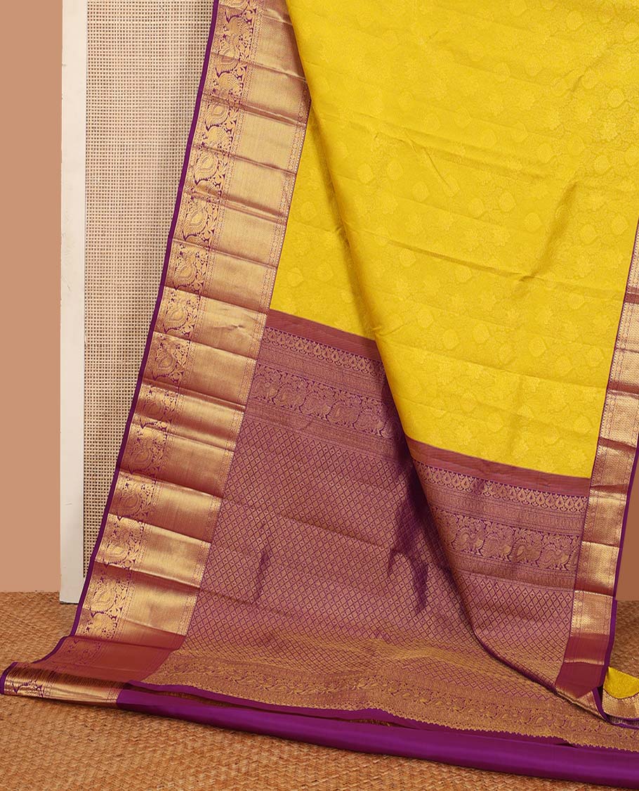 Yellow jacquard wedding silk saree, contrast border of thilakam, rudraksham, and mayil designs, and ogee design pallu