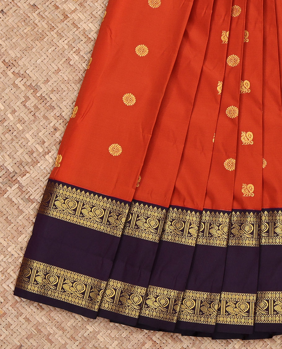 Rust Budget Silk Saree, Accentuated with Peacock and Chakram Buttas All Over Its Body, Complemented by a Contrast Traditional Zari Rettai Pettu Border of Peacock Designs, Pallu Steeped Thilakam Designs, and Paired with a Contrast Blouse