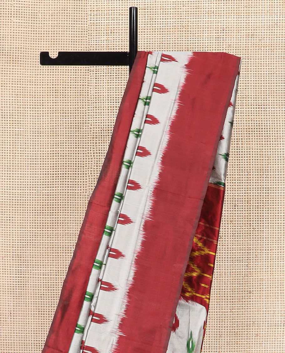 Grey Ikkat Silk Saree Adorned with Ikkat Buttas, Featuring a Contrast Plain Border, Complemented by a Pallu Ikkat Woven in an Ogee Pattern