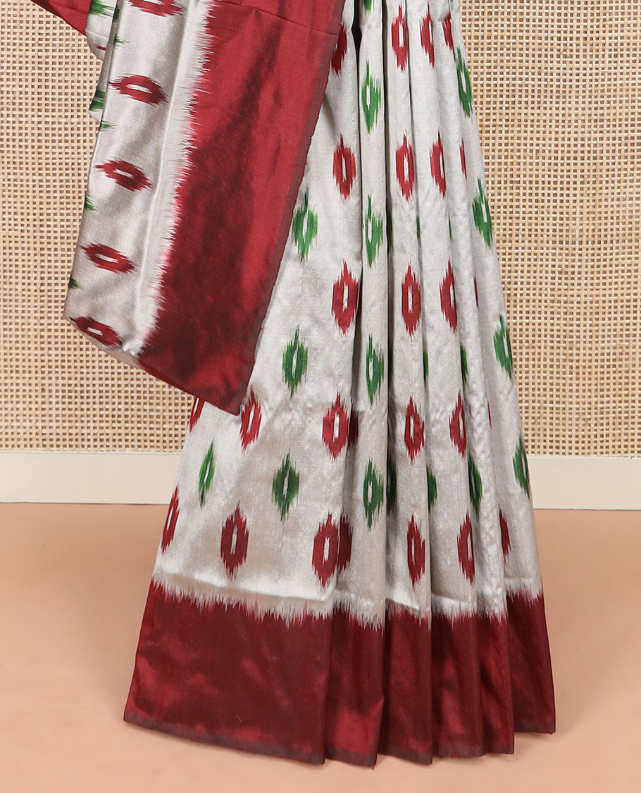 Grey Ikkat Silk Saree Adorned with Ikkat Buttas, Featuring a Contrast Plain Border, Complemented by a Pallu Ikkat Woven in an Ogee Pattern