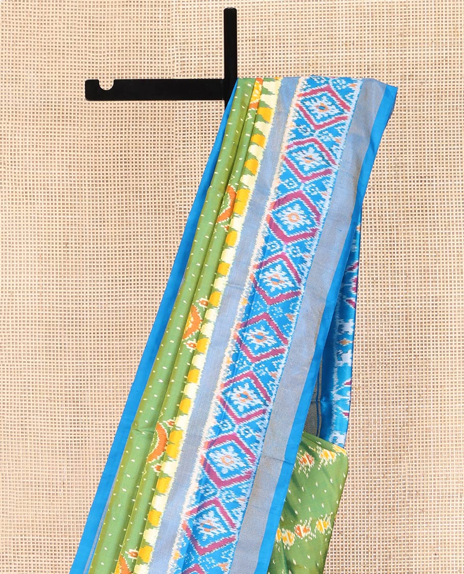 Green Ikkat Silk Saree, Enriched with Elephant Motifs Ikkat Weave All Over Its Body, Complemented by a Contrast Temple Border of Diamond Designs, Pallu of Ikkat Designs, and Paired with a Contrast Blouse