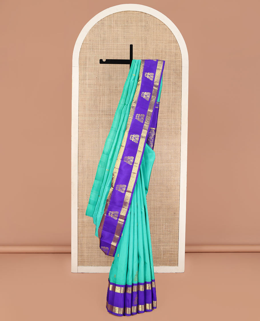 Turquoise Kanchipuram Silk Saree, Beautified with Zari Buttas on Its Body, Complemented by Contrast One-Sided Korvai Border of Diamond Designs, Pallu Steeped with Paisley and Floral Designs, and Comes Without a Blouse