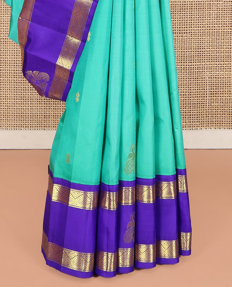 Turquoise Kanchipuram Silk Saree, Beautified with Zari Buttas on Its Body, Complemented by Contrast One-Sided Korvai Border of Diamond Designs, Pallu Steeped with Paisley and Floral Designs, and Comes Without a Blouse