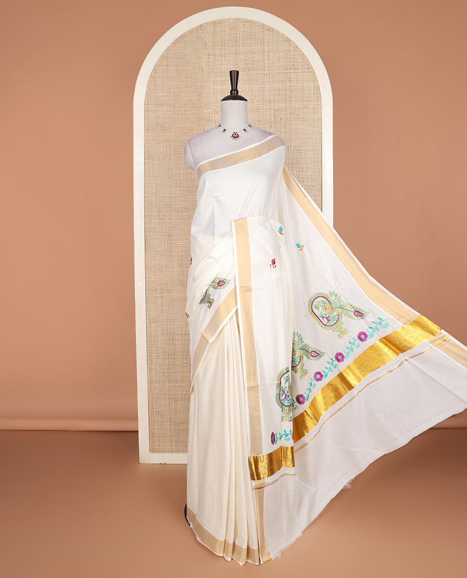 Cream floral motifs embroidered Kerala cotton saree, bavanji border, and peacock embroidered pallu