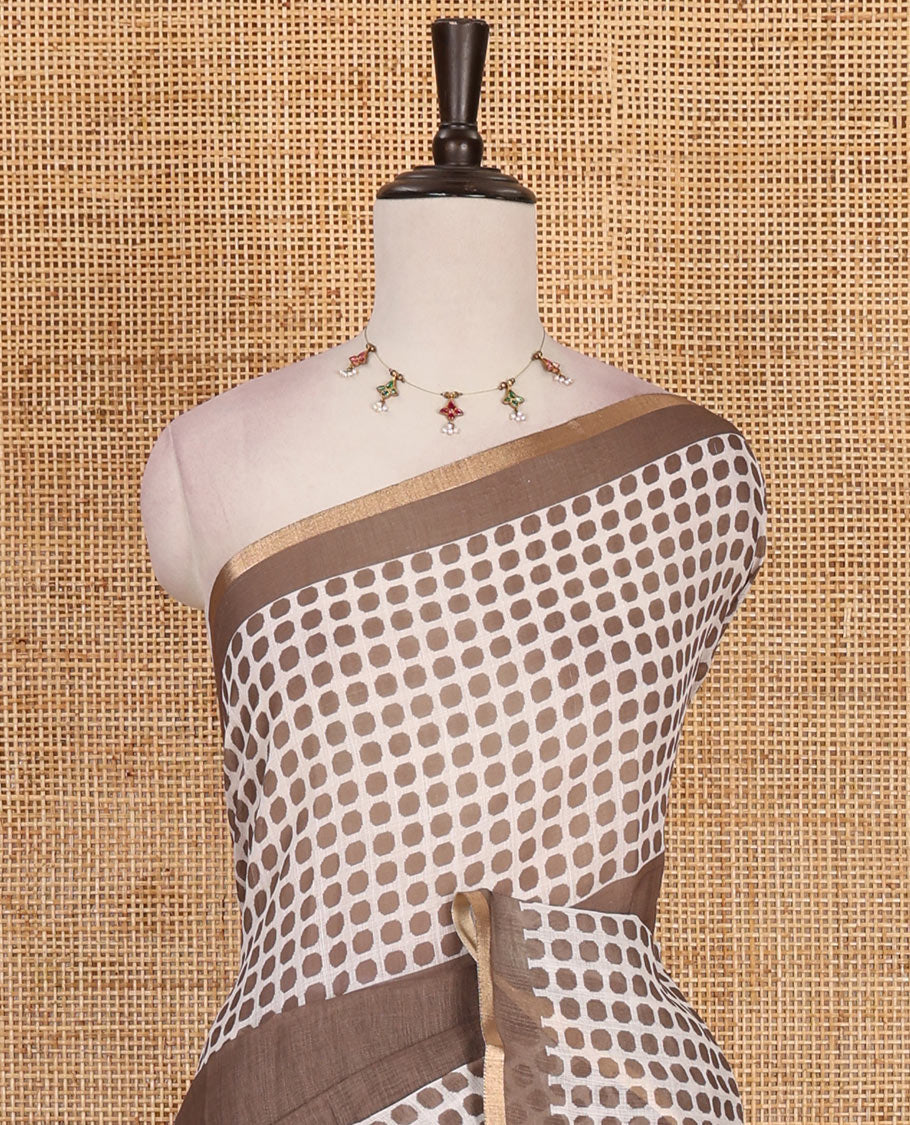 Brown plain and polka dots printed linen cotton saree with piping zari border, floral-geometric print pallu, and contrast flower buttas printed blouse
