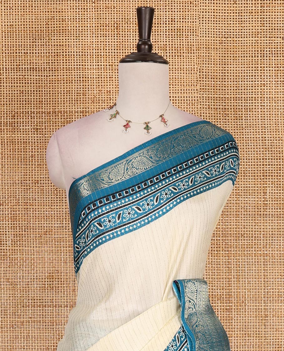 Cream-rama blue zari striped dola silk saree, contrast traditional zari border of leaf creeper, Ajrakh printed pallu, and Ajrakh printed blouse