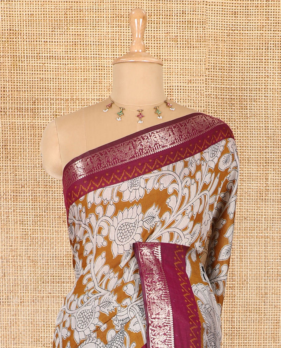 Mustard kalamkari floral vine and peacock printed muslin cotton saree, contrast zari border, kalamkari peacock printed pallu, and a contrast coin buttas printed blouse
