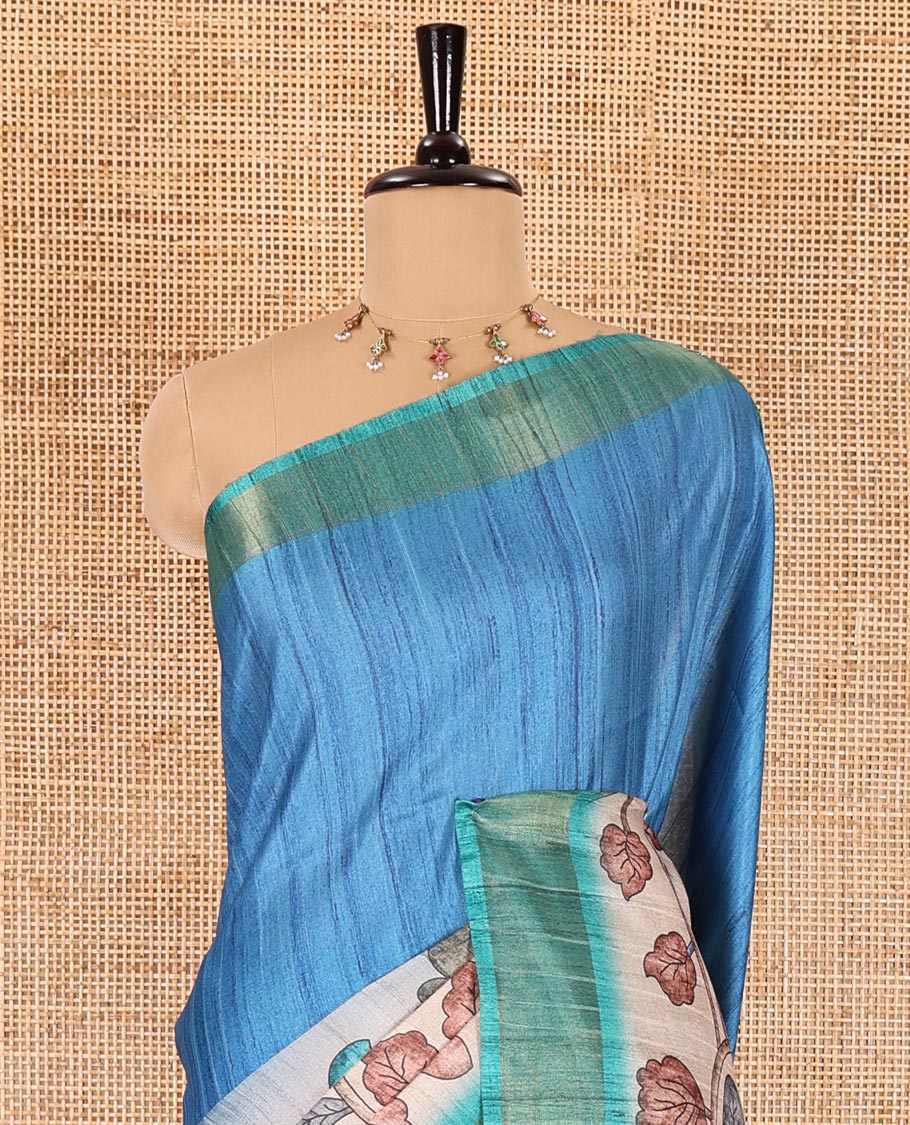 Blue plain fancy tussar saree, contrast floral printed border, floral vine printed pallu, and a contrast plain blouse