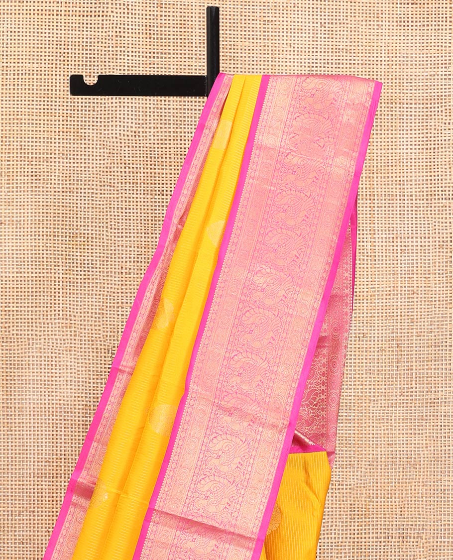 Yellow Vasundhara Silk Saree, Detailed with Zari Buttas and Stripes All Over Its Body, Complemented by a Contrast Border of Rekku, Muthu, Poun, Chakram, and Mayil Designs, Grand Manga Design Pallu, and Paired with a Contrast Blouse