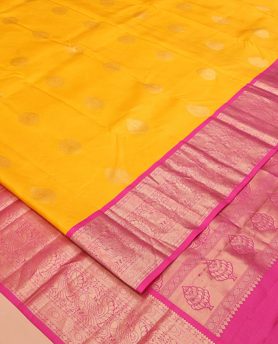 Yellow Vasundhara Silk Saree, Detailed with Zari Buttas and Stripes All Over Its Body, Complemented by a Contrast Border of Rekku, Muthu, Poun, Chakram, and Mayil Designs, Grand Manga Design Pallu, and Paired with a Contrast Blouse
