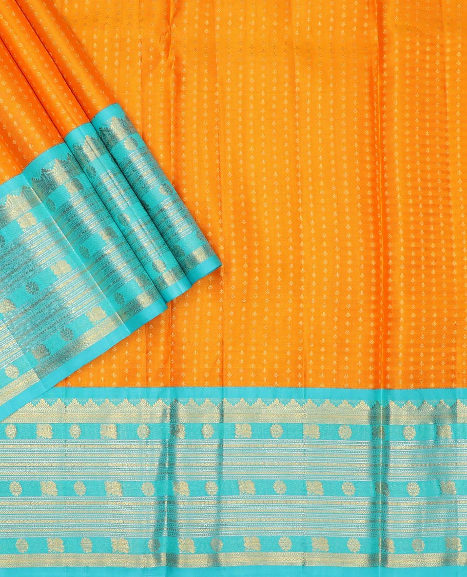 Orange pure-silk half-saree, buttas with a contrast mayil chakram bordered skirt, contrast blouse, and a leaf jaal dhavani