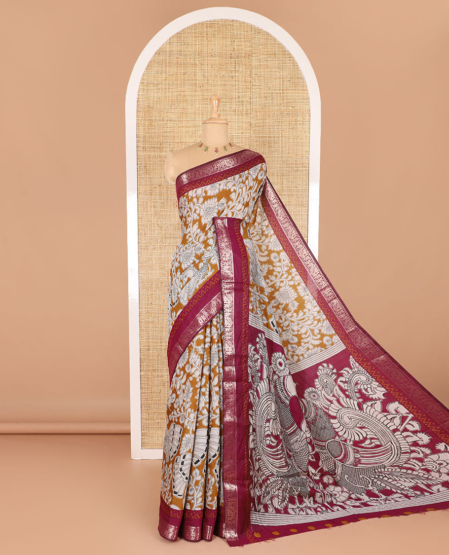 Mustard kalamkari floral vine and peacock printed muslin cotton saree, contrast zari border, kalamkari peacock printed pallu, and a contrast coin buttas printed blouse