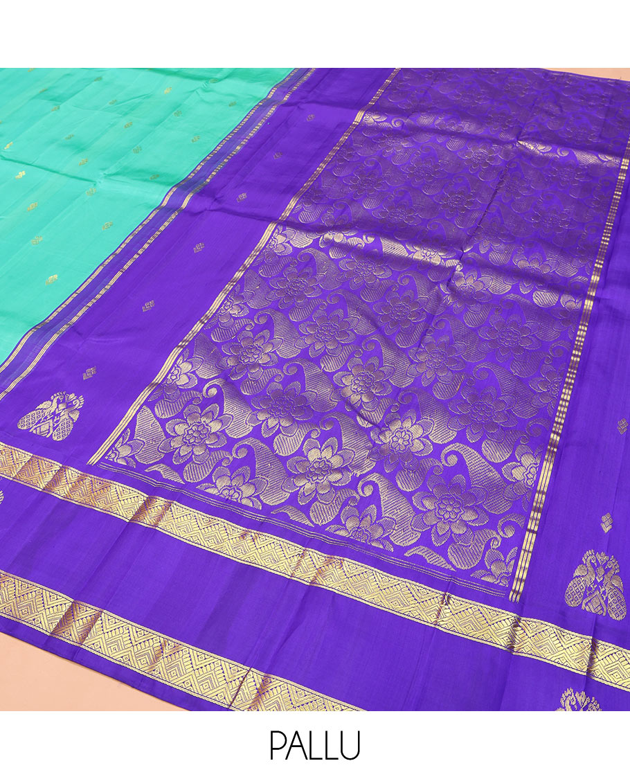 Turquoise Kanchipuram Silk Saree, Beautified with Zari Buttas on Its Body, Complemented by Contrast One-Sided Korvai Border of Diamond Designs, Pallu Steeped with Paisley and Floral Designs, and Comes Without a Blouse