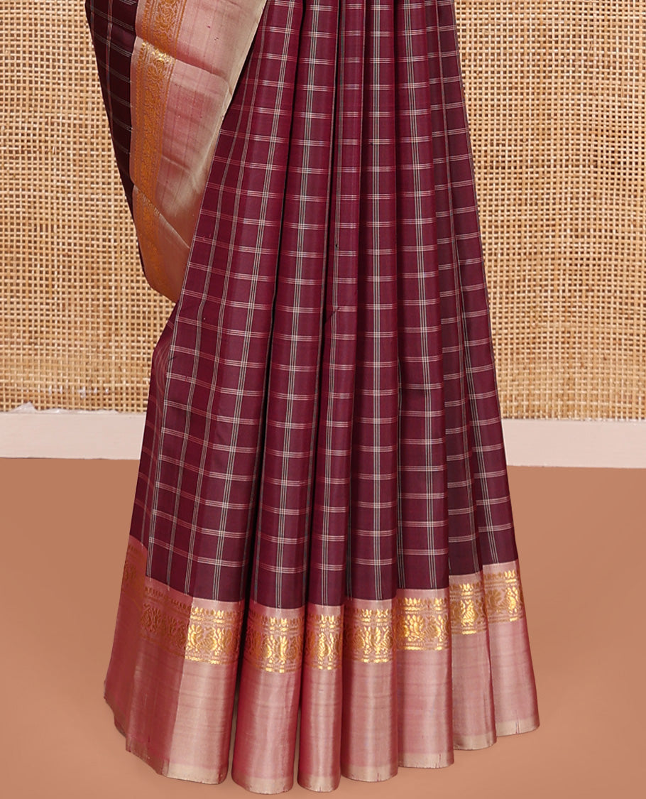Maroon checked Kanchipuram silk saree, contrast kaal eragina border of thilakam mokku, muthu, and mayil designs, and zari striped pallu
