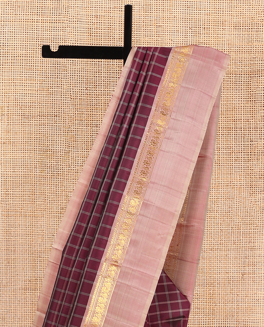 Maroon checked Kanchipuram silk saree, contrast kaal eragina border of thilakam mokku, muthu, and mayil designs, and zari striped pallu