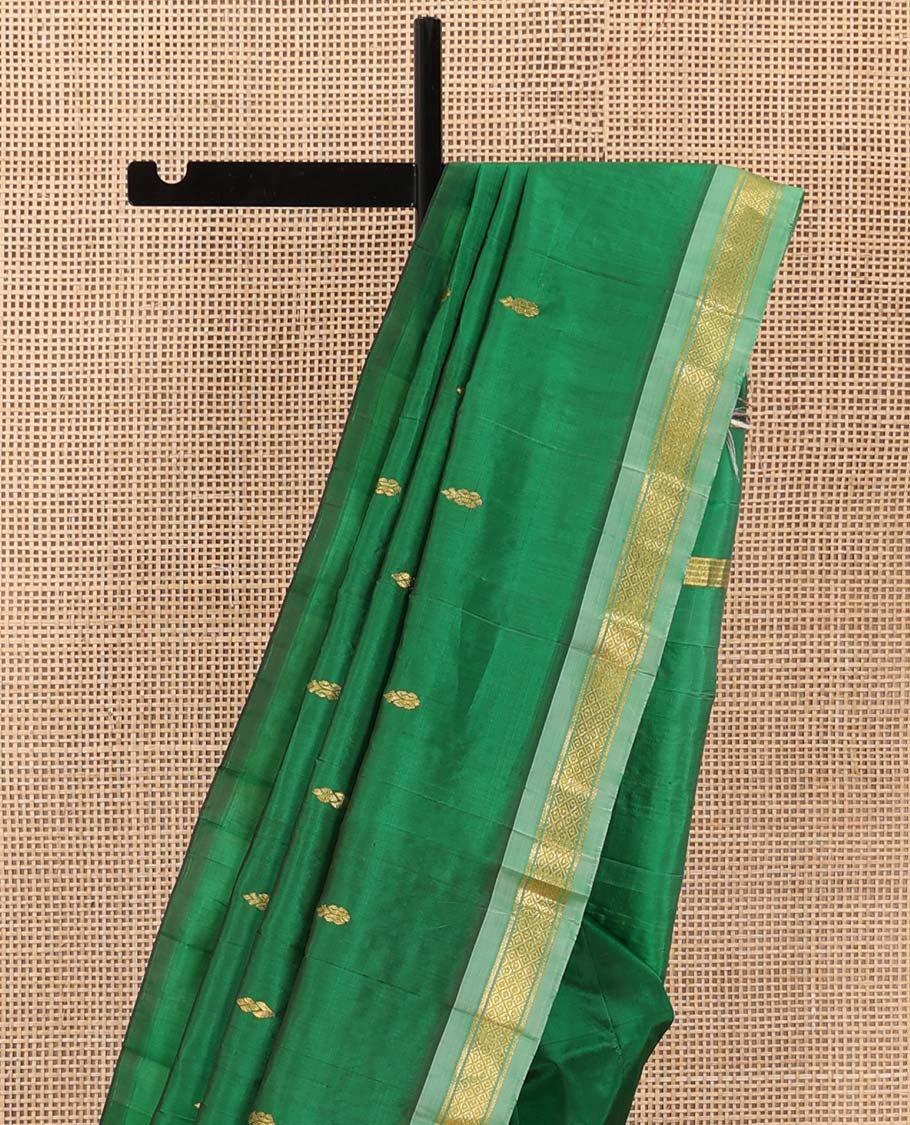 Green Kanchipuram Silk Saree, Beautified with Zari Buttas All Over Its Body, Complemented by Contrast One-Sided Border of Rekku, Banaras, and Mayil Kann Designs, Pallu of Zari Designs, and Comes Without a Blouse