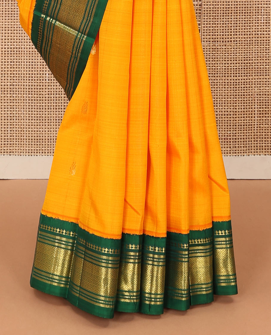 Yellow zari buttas Kanchipuram silk saree, contrast one-sided korvai border of panner, sombu, banaras, muthu, and mayil kann and zari design pallu