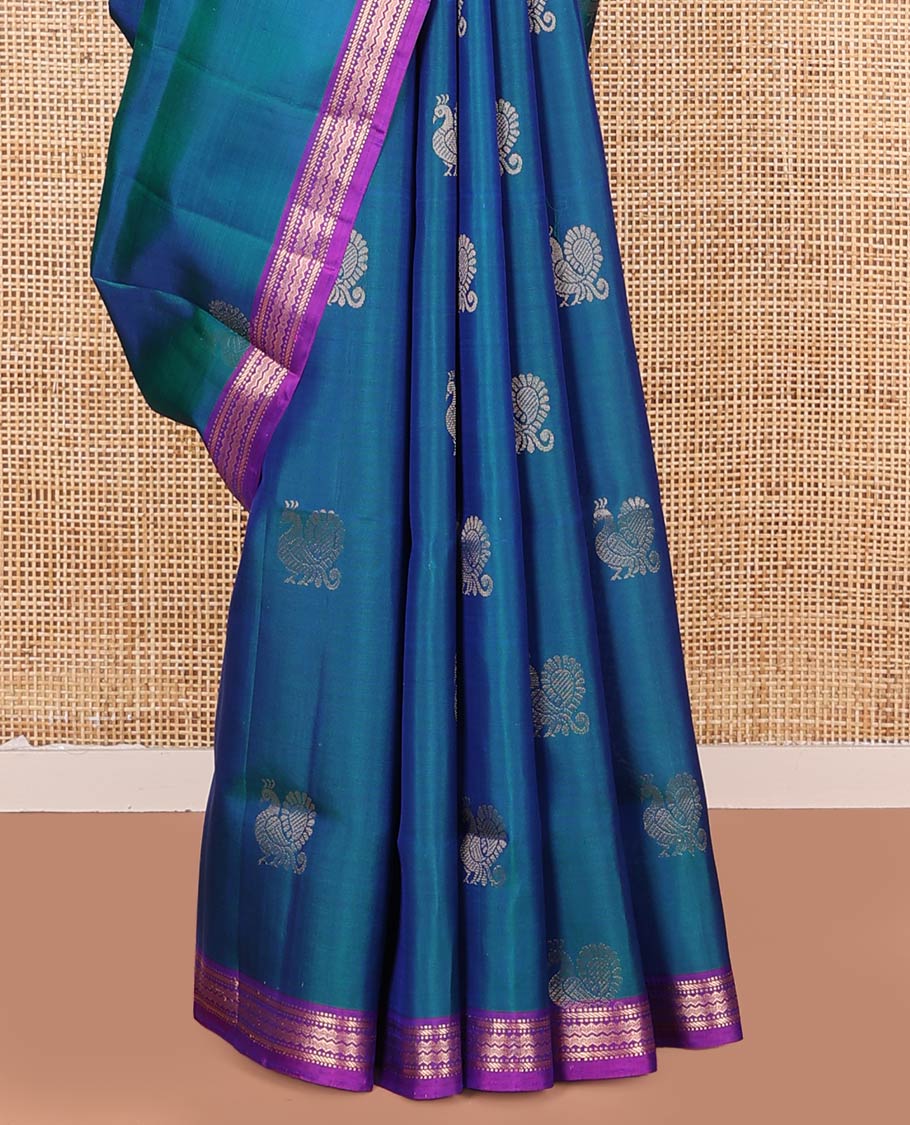 Blue Mayuri Soft Silk Saree, Decorated with Mayil Buttas All Over Its Body, Complemented by Contrast Border of Muthu, Banaras, and Chevron Designs, Pallu Elevated with Floral Creeper Designs, and Paired with Contrast Blouse