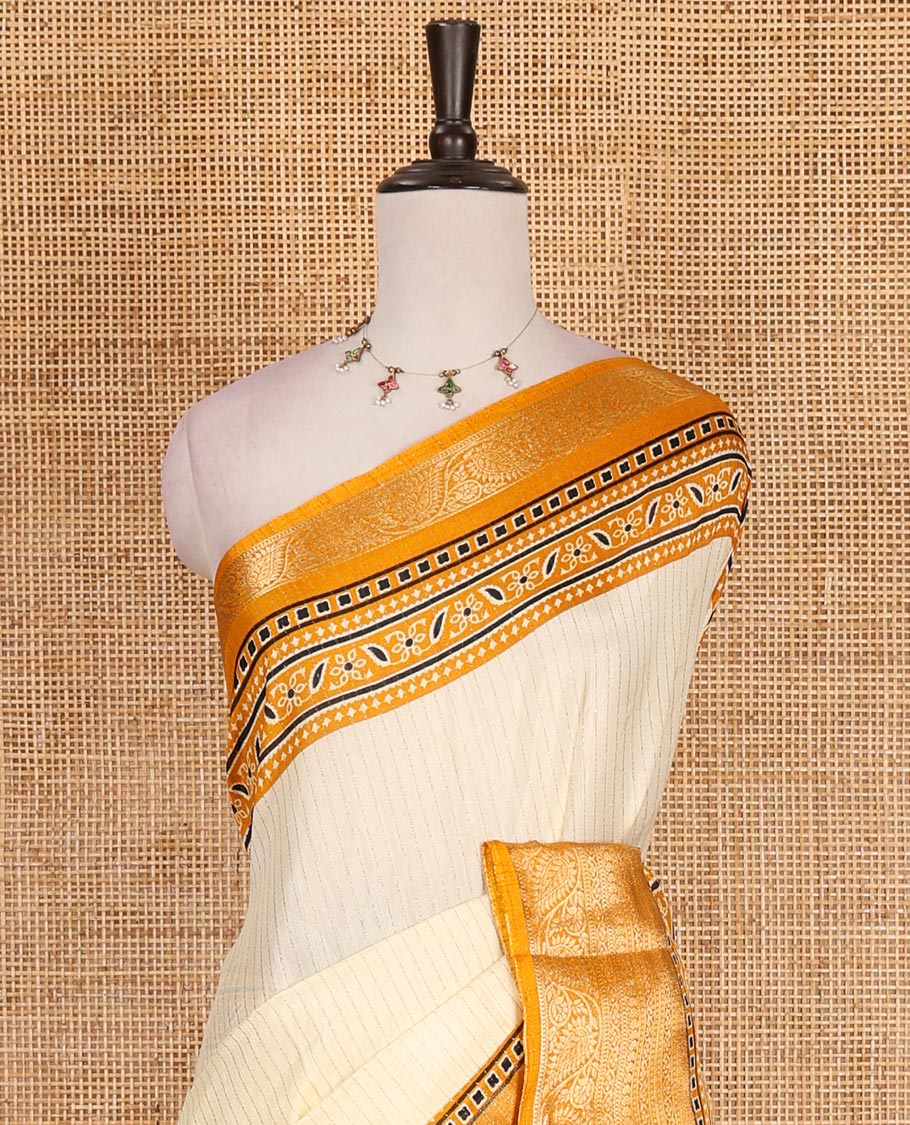 Cream-mustard zari striped dola silk saree, contrast traditional zari border of leaf creeper, Ajrakh printed pallu, and Ajrakh printed blouse