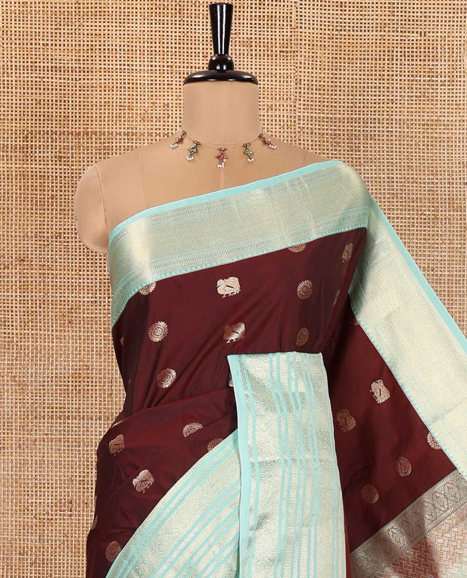 Maroon Kanchipuram Budget Silk Saree, Adorned with Peacock Chakram Buttas All Over Its Body, Complemented by a Contrast Traditional Zari Border of Floral-Bird Designs, Pallu Enriched with Geometric Patterns, and Paired with a Matching Blouse