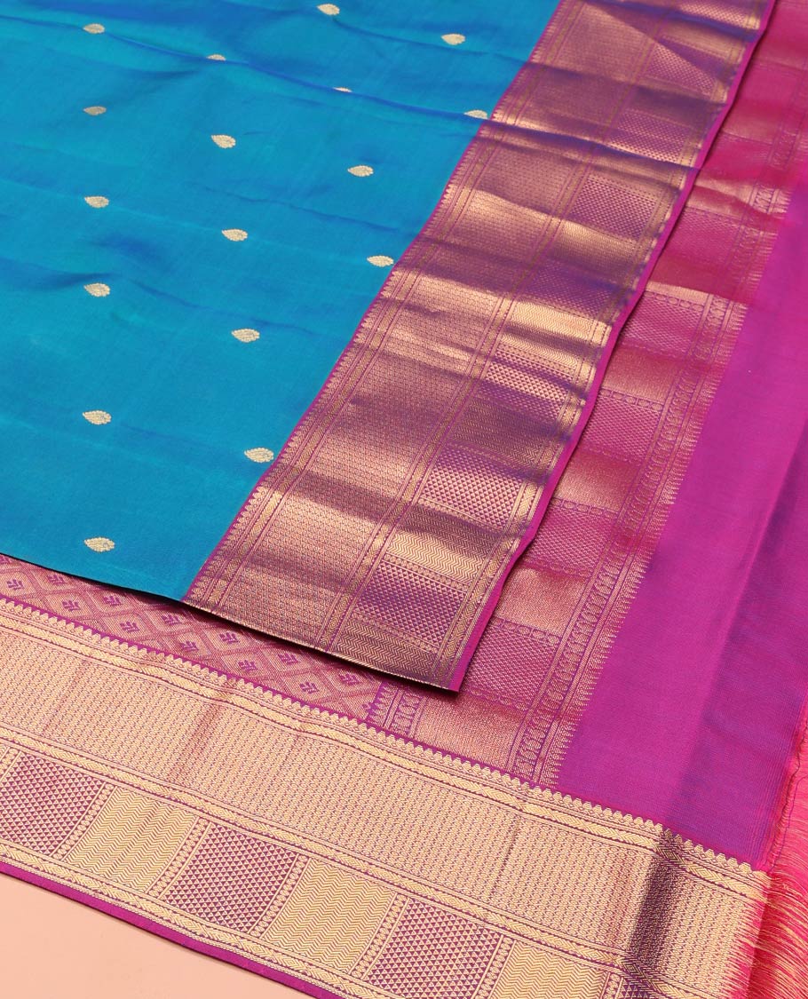 Blue Vasundhara Lite-Silk Mix Saree Highlighted with Zari Buttas on Its Body, Complemented by a Contrast Border of Thilakam Mokku, Ara Maadam, Vanki, and Then Kuli Kann Designs, Pallu Elevated with Jaal Designs, and Paired with a Contrast Blouse