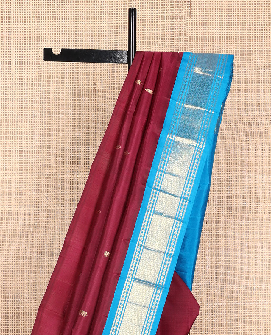 Maroon zari buttas Kanchipuram silk saree, contrast one-sided korvai border of lavangam, and mayil kann designs, and zari design pallu