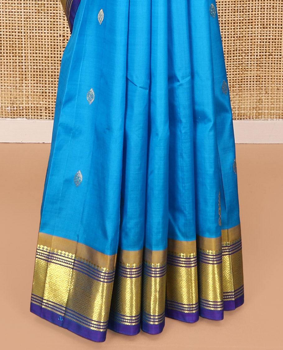 Blue Kanchipuram Silk Saree, Highlighted with Zari Buttas All Over Its Body, Complemented by a Contrast One-Sided Border of Panner Sombu, Banaras, Muthu, and Mayil Kann Designs, Pallu of Floral Designs, and Comes Without a Blouse