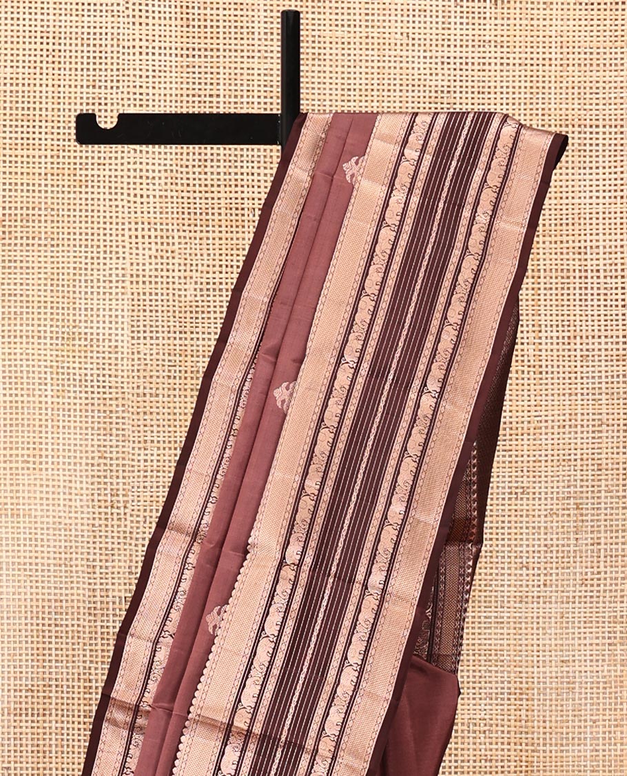 Brown Vasundhara Silk Saree, Detailed with Iruthakshi Buttas All Over Its Body, Complemented by a Contrast Border of Thilakam Mokku, Vanki, Yaanai, and Muthu Designs, Grand Pallu, and Paired with a Contrast Blouse