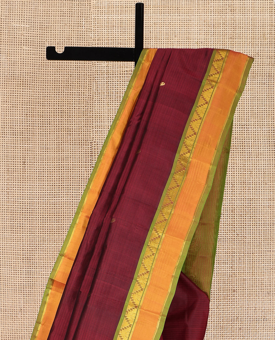 Maroon Kanchipuram Silk Saree, Sparsely Woven with Vazhaipoo Stripes and Buttas on Its Body, Complemented by Contrast Rettai Pettu Border of Thazampoo Rekku, and Kathir Designs, Zari-Striped Pallu, and Paired with a Contrast Blouse