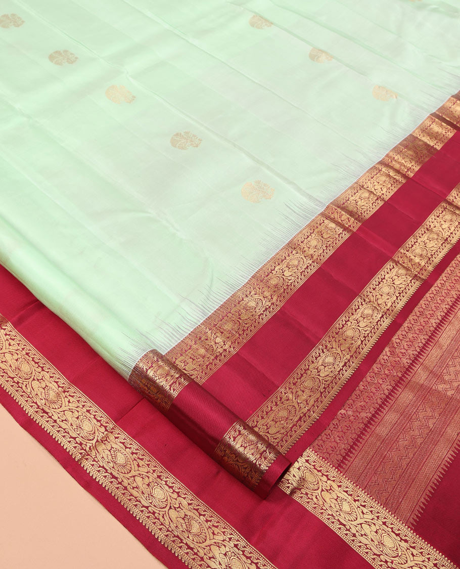 Green Zari Buttas Vasundhara Silk Saree Adorned with a Contrast Rettai Pettu Border of Rekku, Muthu, and Kodi Mayil Designs, Grand Pallu, and a Contrast Blouse