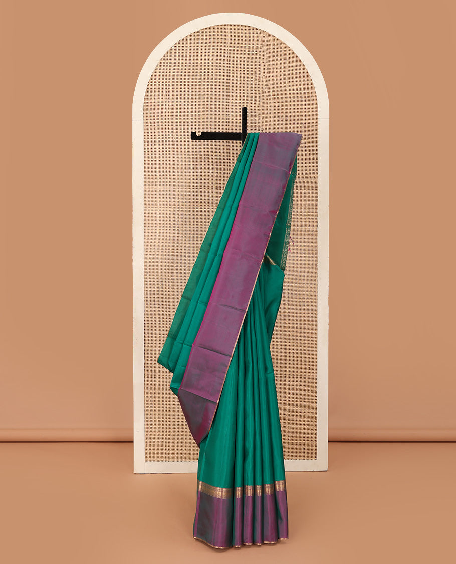 Green plain Kanchipuram silk saree, contrast ganga jamuna rettai pettu border of rekku, neli, banaras, and rudraksham designs, and pallu of kathir, rudraksham, neli, poun, ara bogudi, and ara maadam