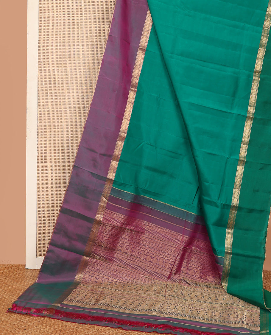 Green plain Kanchipuram silk saree, contrast ganga jamuna rettai pettu border of rekku, neli, banaras, and rudraksham designs, and pallu of kathir, rudraksham, neli, poun, ara bogudi, and ara maadam