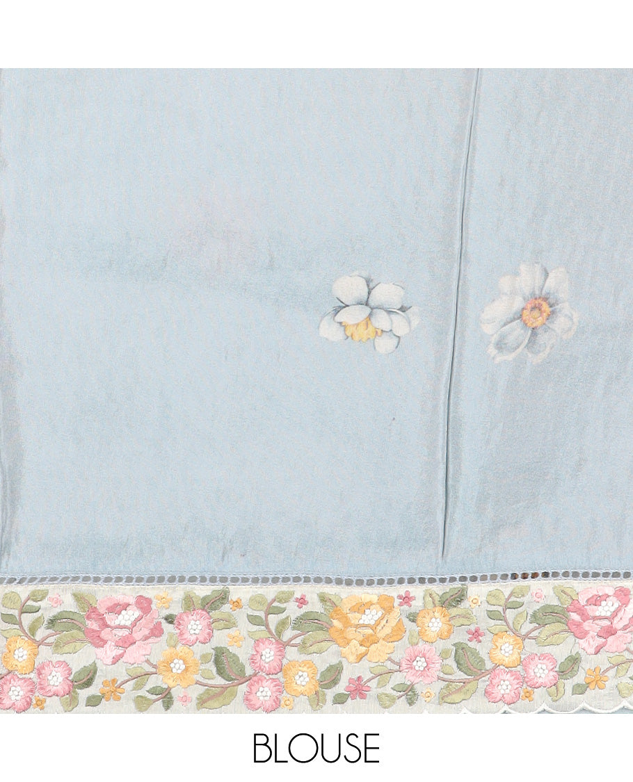 Pastel blue dobby-style buttas dola silk saree, contrast floral embroidered scallop border, and floral printed pallu