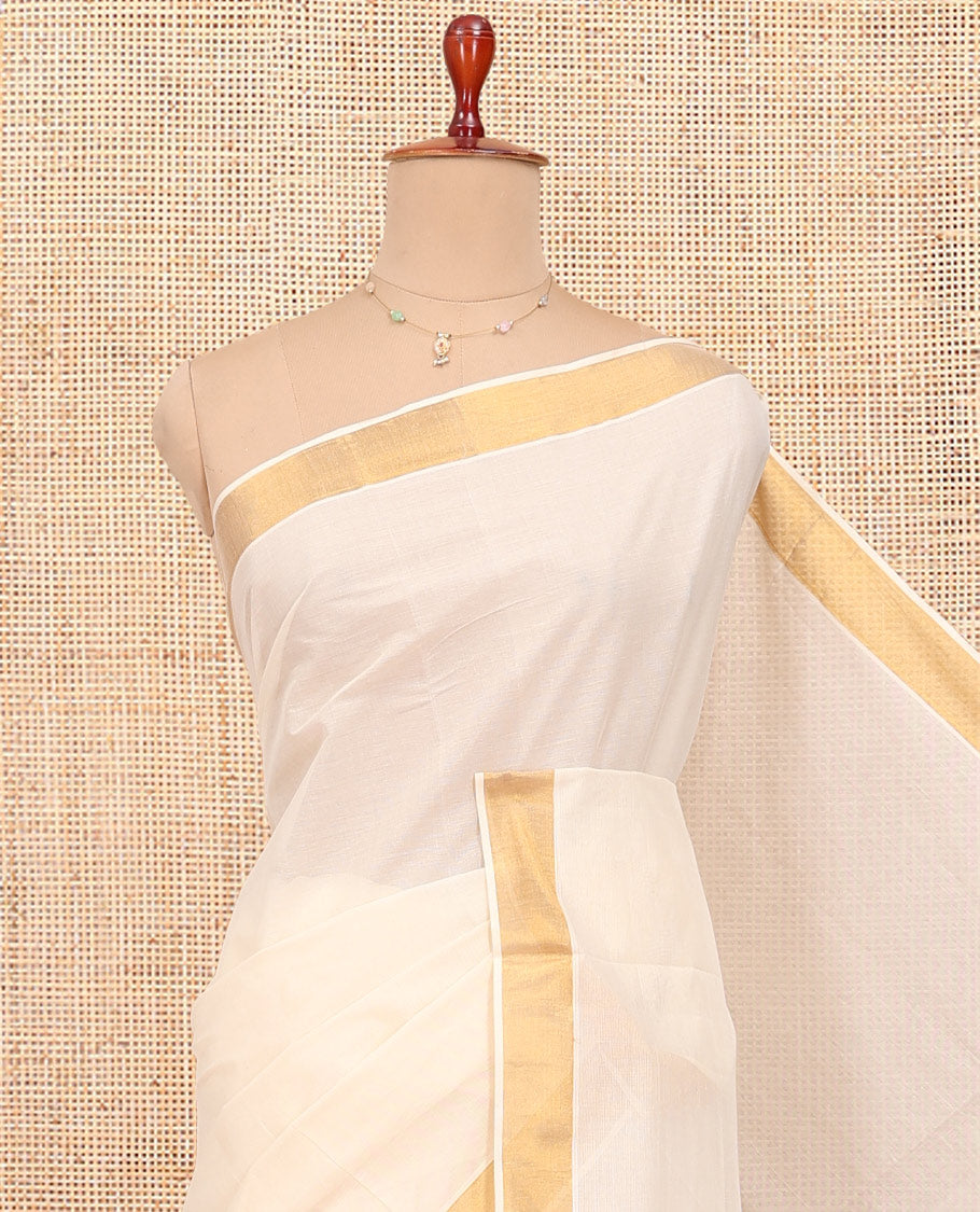 Cream Kerala Cotton Saree, Decked up with Zari Buttas All Over Its Body, a Zari Bavanji Border, Pallu of Intricate Designs, and Paired with a Matching Blouse