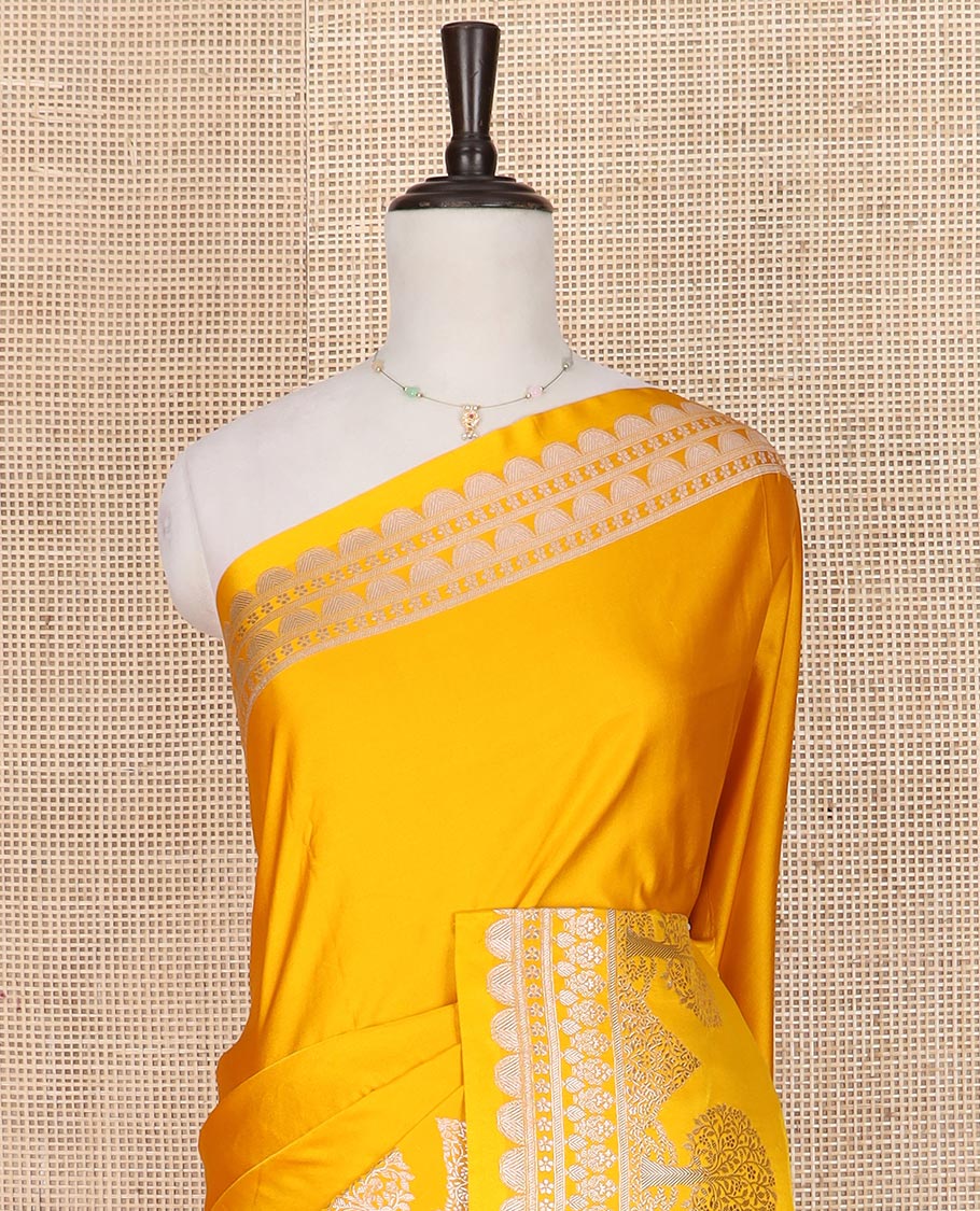 Yellow plain mushru silk saree, self-border of scallop design, floral, and tree motifs, and intricately designed pallu