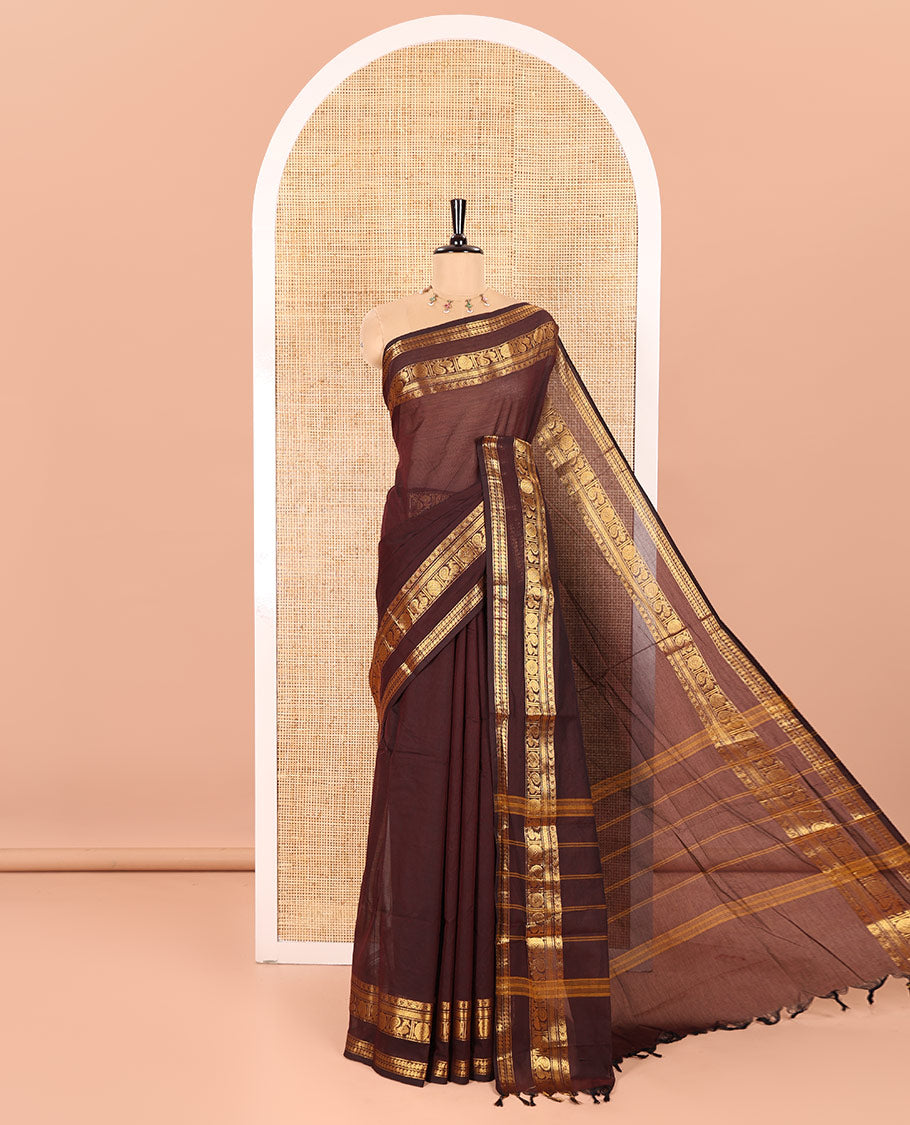 Coffee Brown Plain Chettinad Cotton Saree Elevated with a Gleaming Zari Rettai Pettu Border Featuring Peacock, Rudraksham, and Manga Designs, Subtly Striped Pallu, and Paired with a Matching Blouse