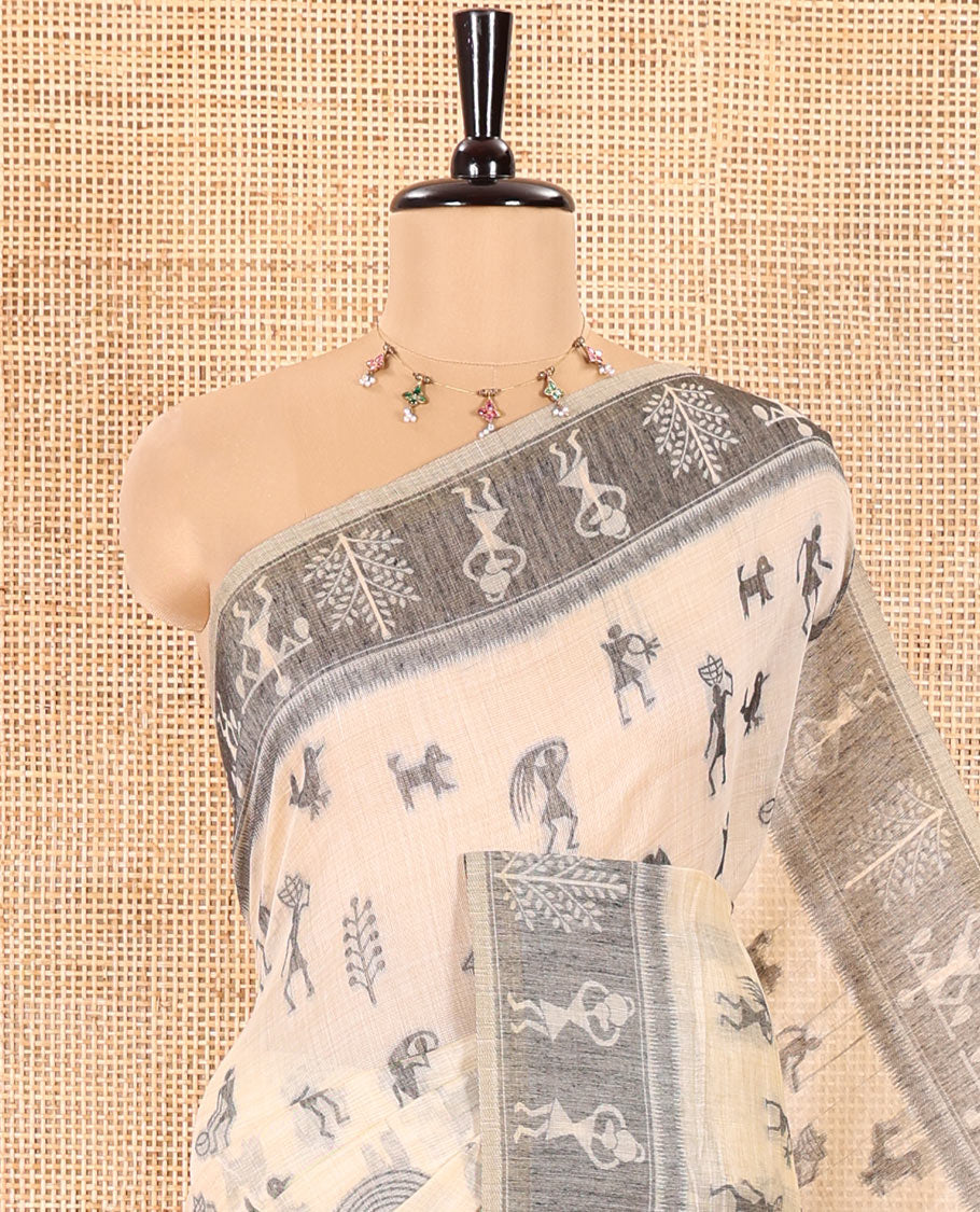 Chikku Munga Cotton Saree Bedecked with Threa Dwoven Warli-Village Theme Motifs All Over Its Body, Subtly Colored Contrast Warli Border, Pallu Depicting Warli Island, and Comes with a Matching Blouse