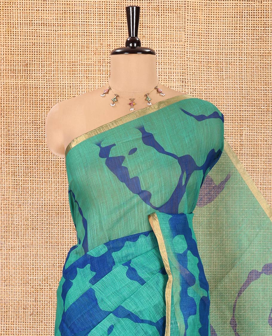 Green Linen Cotton Saree, Adorned with Shibori Printed on Its Body, Subtle Piping Border, Pallu of Floral Vine Print, and Paired with a Contrast Floral Vine Printed Blouse