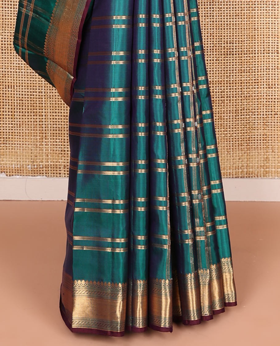 Green butta enclosed checked soft silk saree, zari border of thilakam mokku, banaras, muthu, puli nagam, and vanki designs, and contrast pallu of mayil and yaanai designs