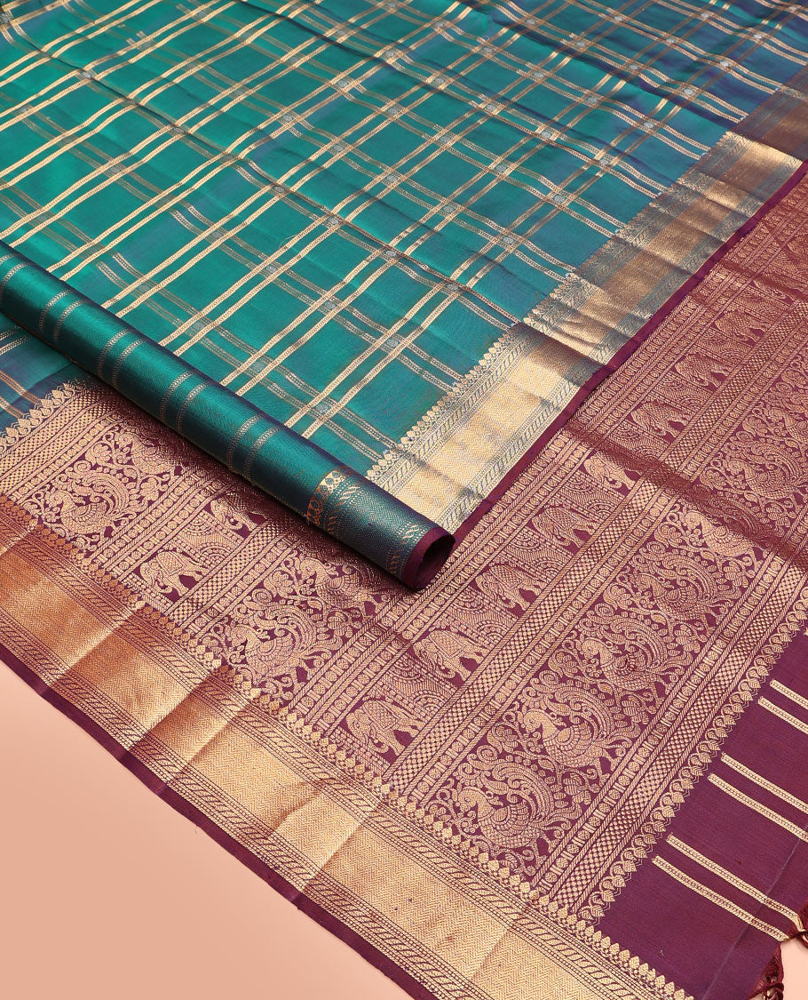 Green butta enclosed checked soft silk saree, zari border of thilakam mokku, banaras, muthu, puli nagam, and vanki designs, and contrast pallu of mayil and yaanai designs