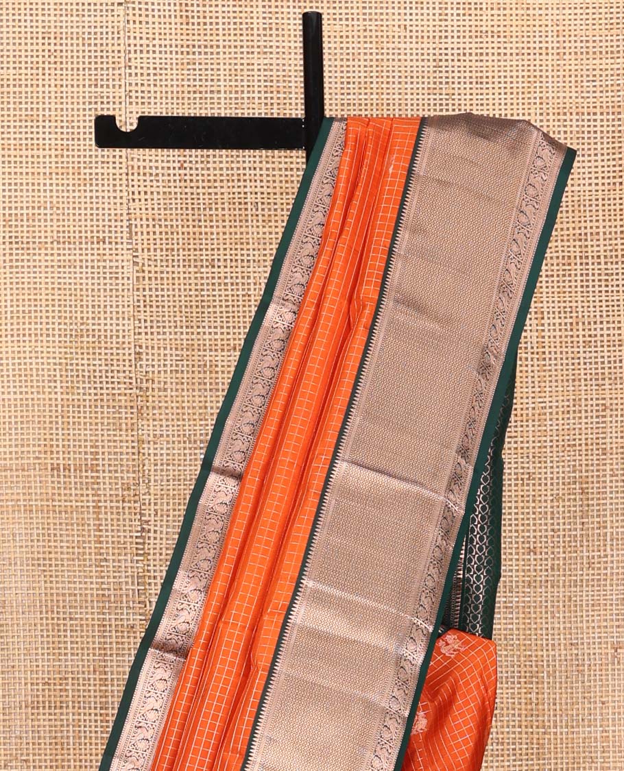 Orange Vasundhara Silk Saree, Embellished with Mayil and Yaali Butta Enclosed Checks on Its Body, Complemented by Contrast Border of Muthu, Rekku, Mayil, and Mayil Kann Designs, Grandly Decked Up Pallu, and Paired with a Contrast Blouse