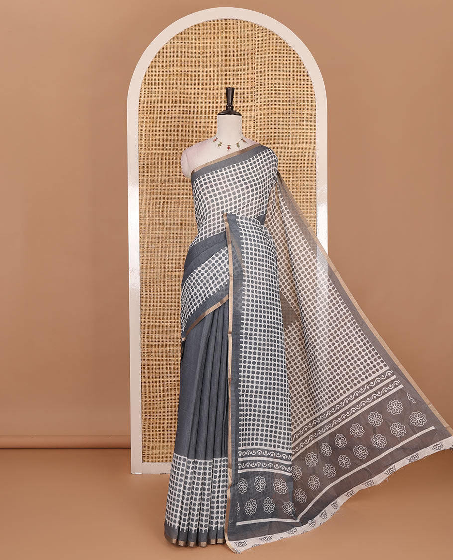 Grey plain and polka dots printed linen cotton saree with piping zari border, floral-geometric print pallu, and contrast flower buttas printed blouse