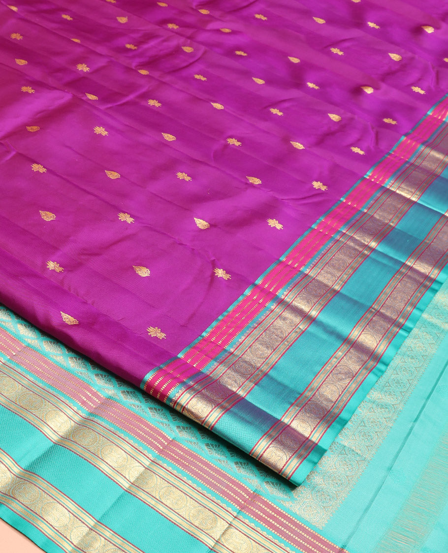 Purple Vasundhara Silk Saree, Beautifully Bedecked with Kamalam Buttas on Its Body, Complemented by a Captivating Contrast Border of Muthu, Chakram, and Mayil Kann Designs, Grand Jaal Pallu, and Paired with a Contrast Blouse