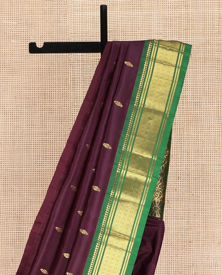 Maroon Kanchipuram Silk Saree, Spotlighted with Zari Buttas on Its Body, Complemented by a Contrast One-Sided Border of Panner Sombu, Banaras, and Jaal Designs, Pallu Features Floral Zari Designs, and Comes Without a Blouse