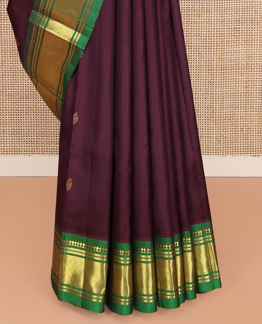 Maroon Kanchipuram Silk Saree, Spotlighted with Zari Buttas on Its Body, Complemented by a Contrast One-Sided Border of Panner Sombu, Banaras, and Jaal Designs, Pallu Features Floral Zari Designs, and Comes Without a Blouse
