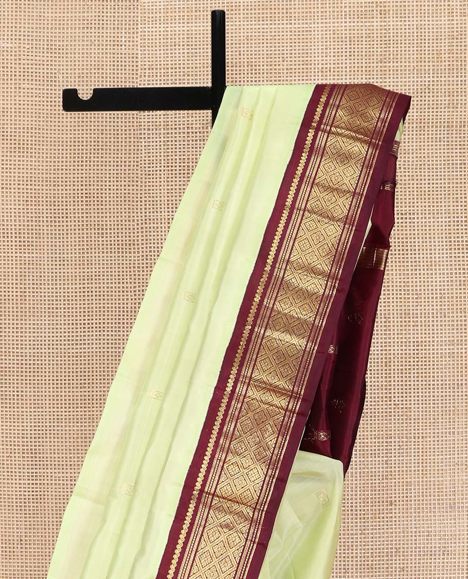 Light Green Kanchipuram Silk Saree, Delicately Woven with Zari Buttas on Its Body, Complemented by a Contrast One-Sided Border of Salngai, Banaras, Muthu, and Jaal Designs, Pallu of Zari Designs, and Comes Without a Blouse